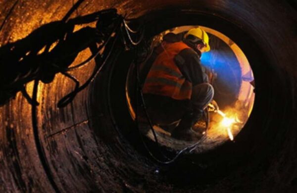 Construction Worker Welding In Pipe